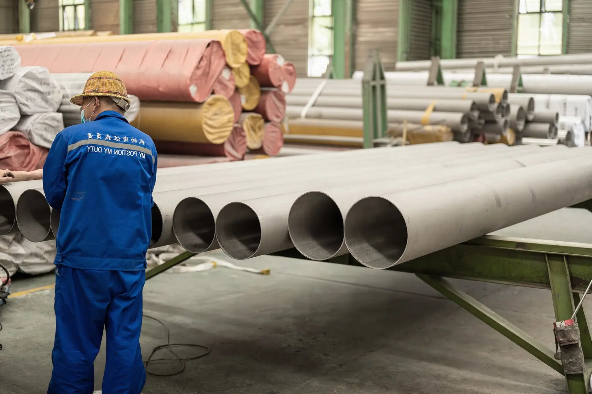 seamless pipe from nickel alloy manufacturer arialloy worker inspecting large pipes